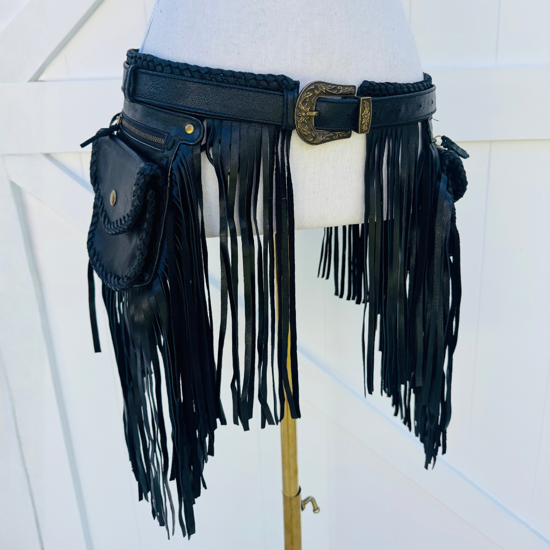 Black leather fringe belt with a matching pouch and decorative buckle, displayed on a white mannequin torso.