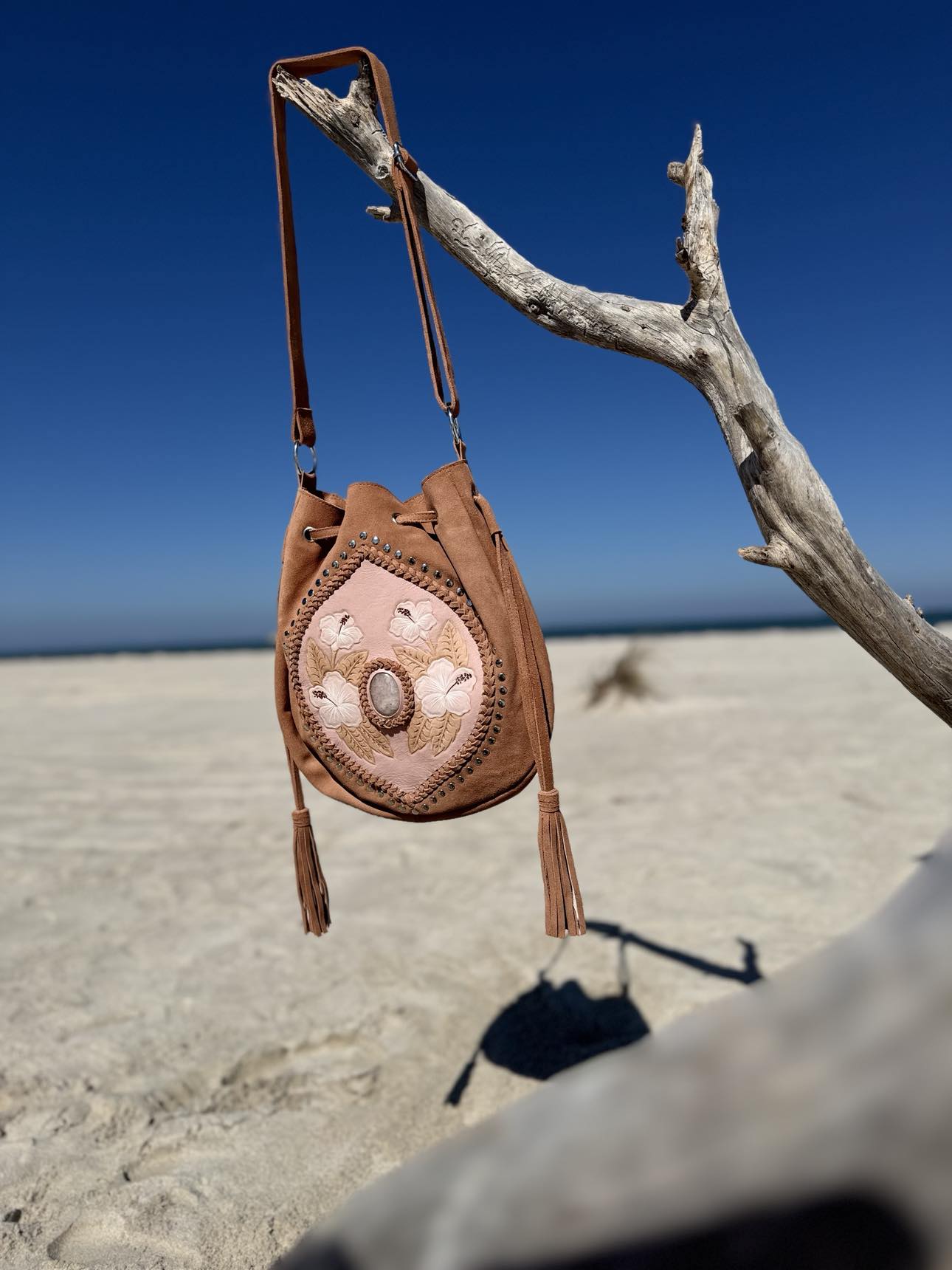 Western-Inspired Hibiscus Suede Crossbody Bag – Stylish crossbody bag with hand-painted hibiscus flowers and rose quartz gemstone, perfect for western and boho fashion lovers.