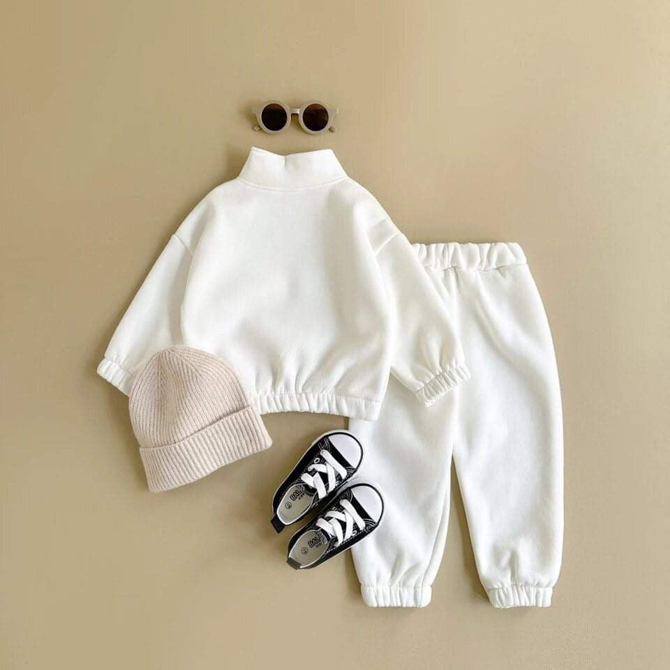 White kids’ tracksuit with soft fleece lining and retro print, offering a stylish and cozy outfit for cooler days.