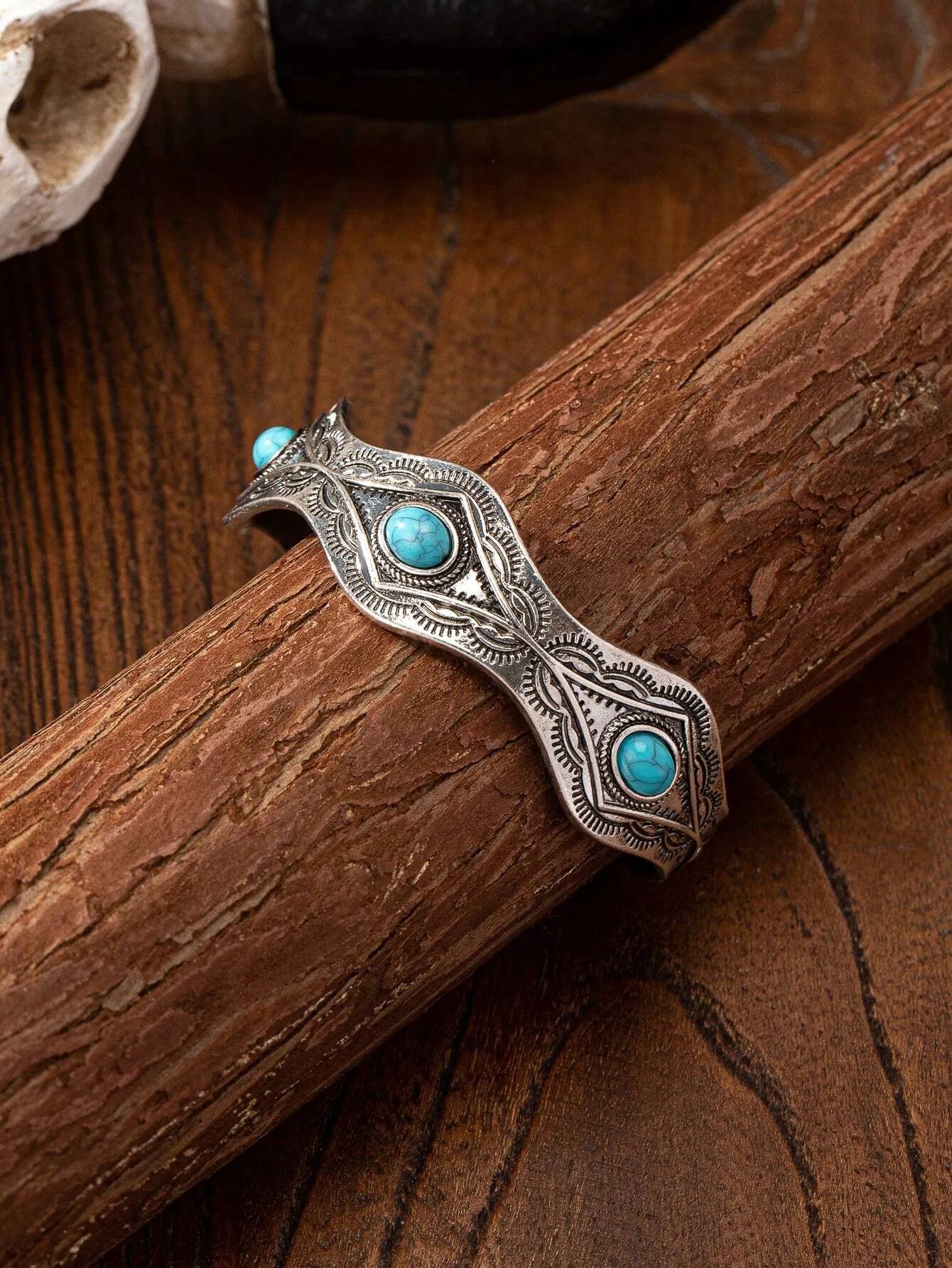 Blue turquoise acrylic decor bracelet – displayed wrapped around a piece of wood