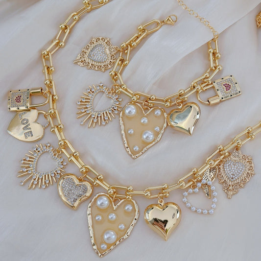 Gold charm bracelet with heart-shaped pendants on a light background