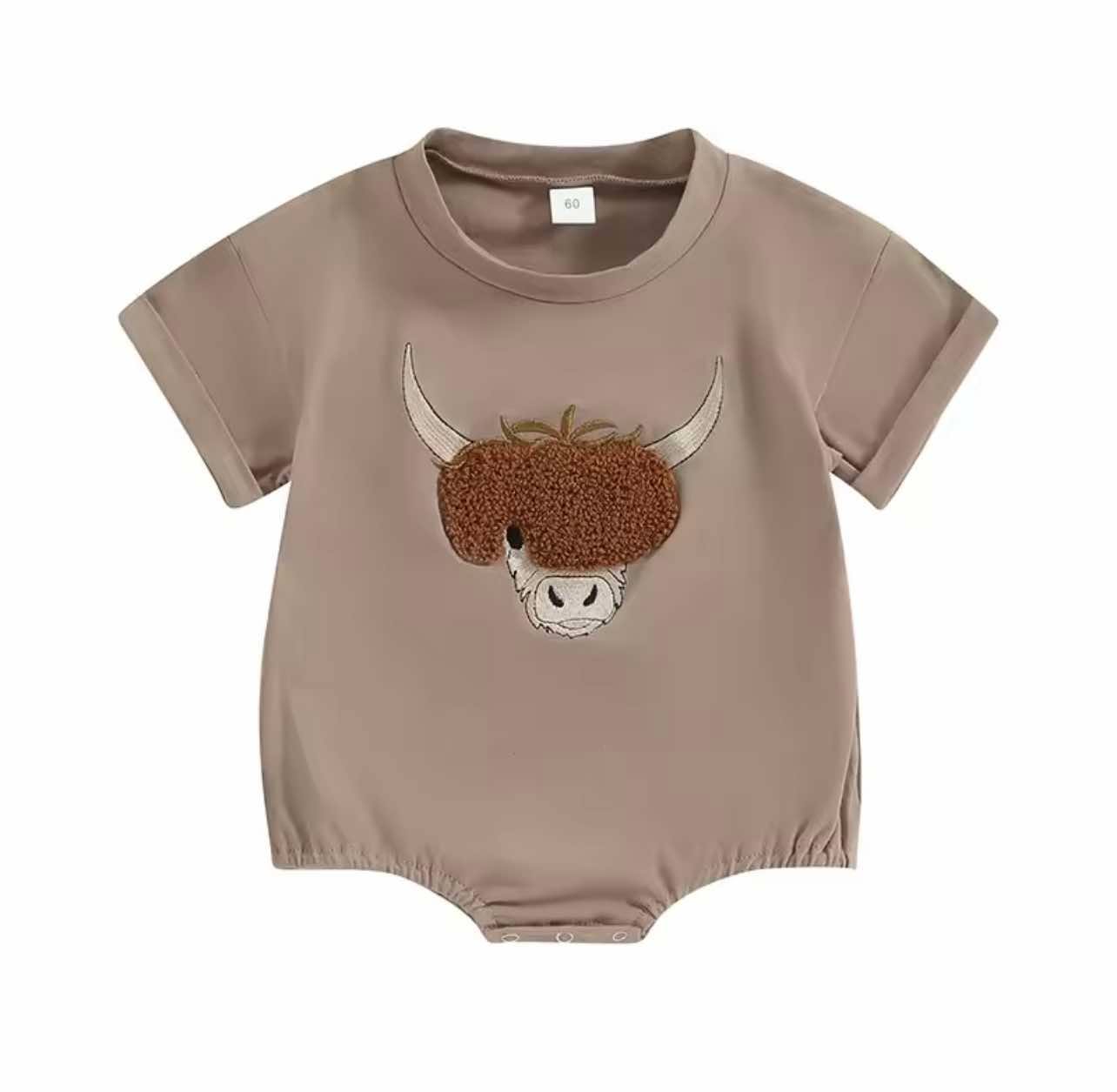 Close-up of embroidered cow patch on soft cotton blend baby romper, perfect for country kids