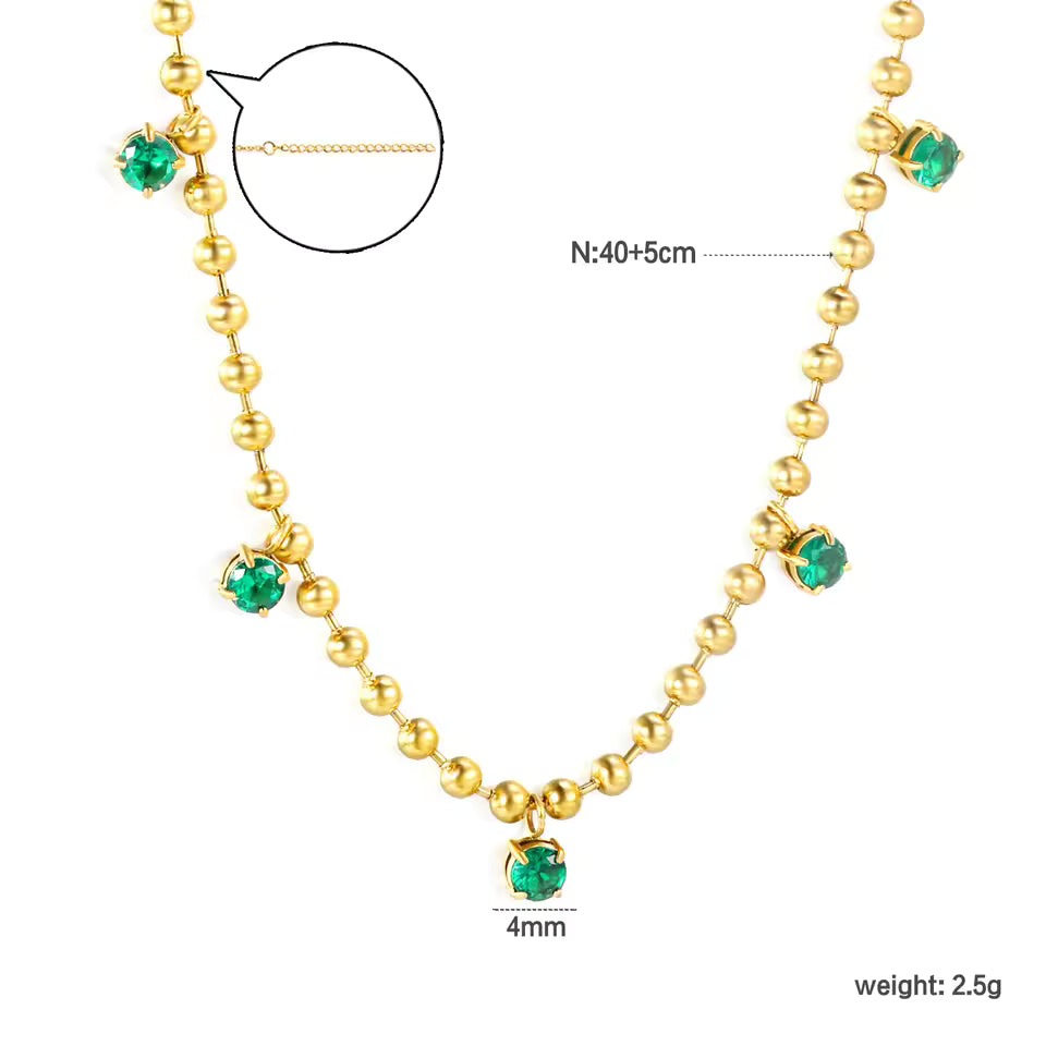 Gold necklace with green gemstones and measurement details on a white background