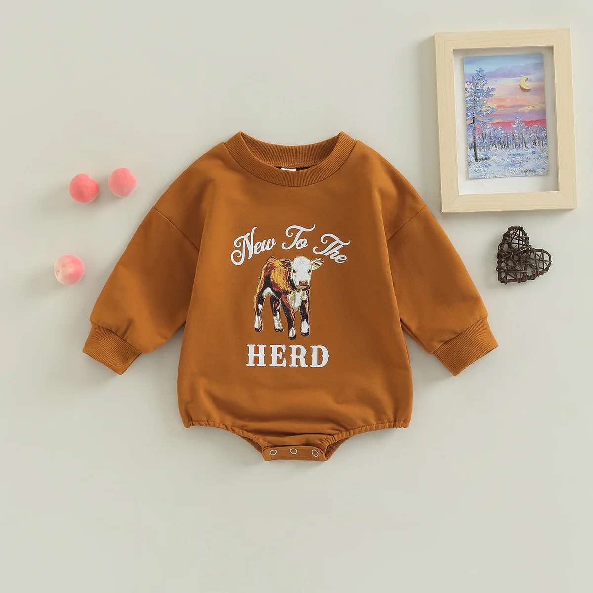 Cosy cow print infant romper with long sleeves, perfect for fall and winter
