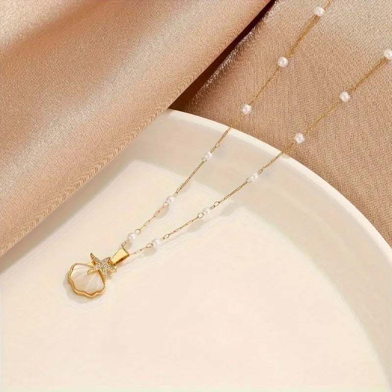 Golden pearl pendant necklace display view on a white and fabric surface
