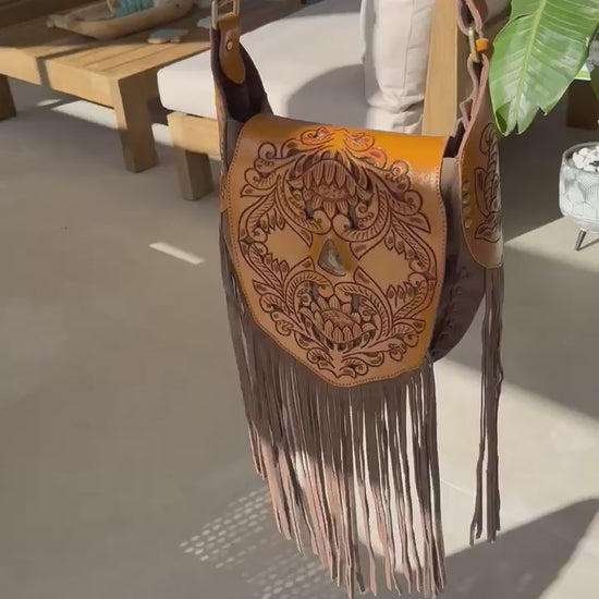 Handcrafted Montana leather bag showcasing Western charm with intricate tooling and soft suede fringe.