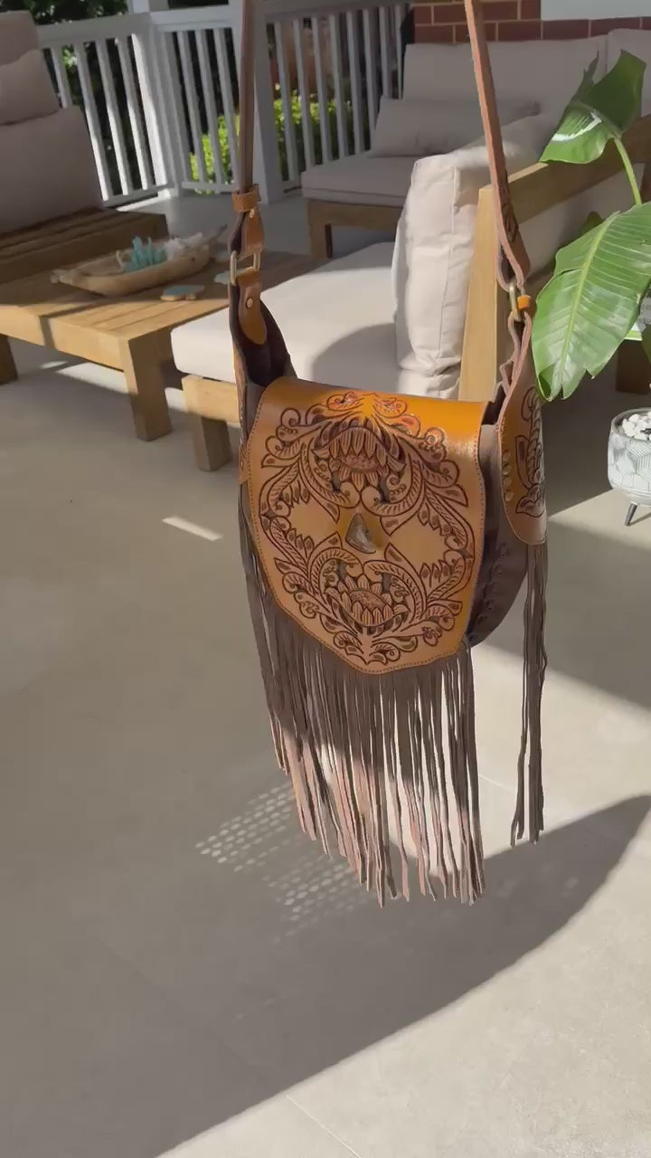 Handcrafted Montana leather bag showcasing Western charm with intricate tooling and soft suede fringe.