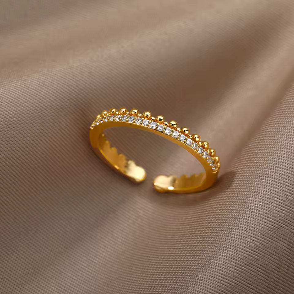 Gold ring with small diamonds on a beige fabric background