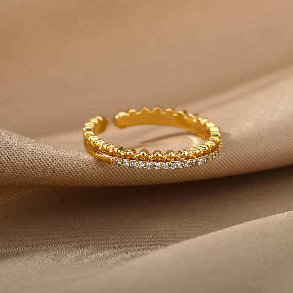 Gold ring with small diamonds on a beige fabric background
