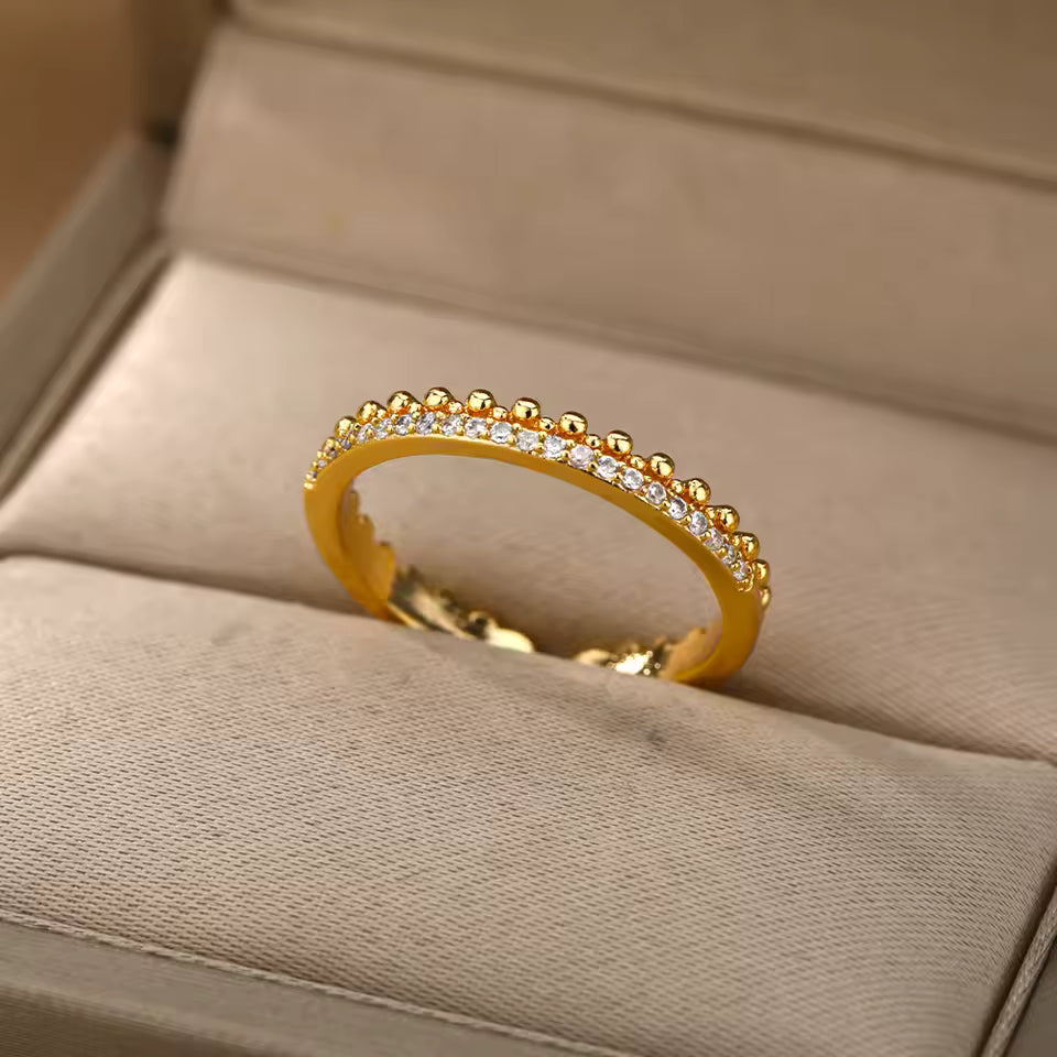 Gold ring with diamonds on a beige cushion