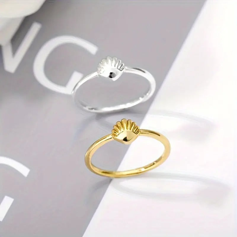 Silvery seashell minimalist ring top view on a white background