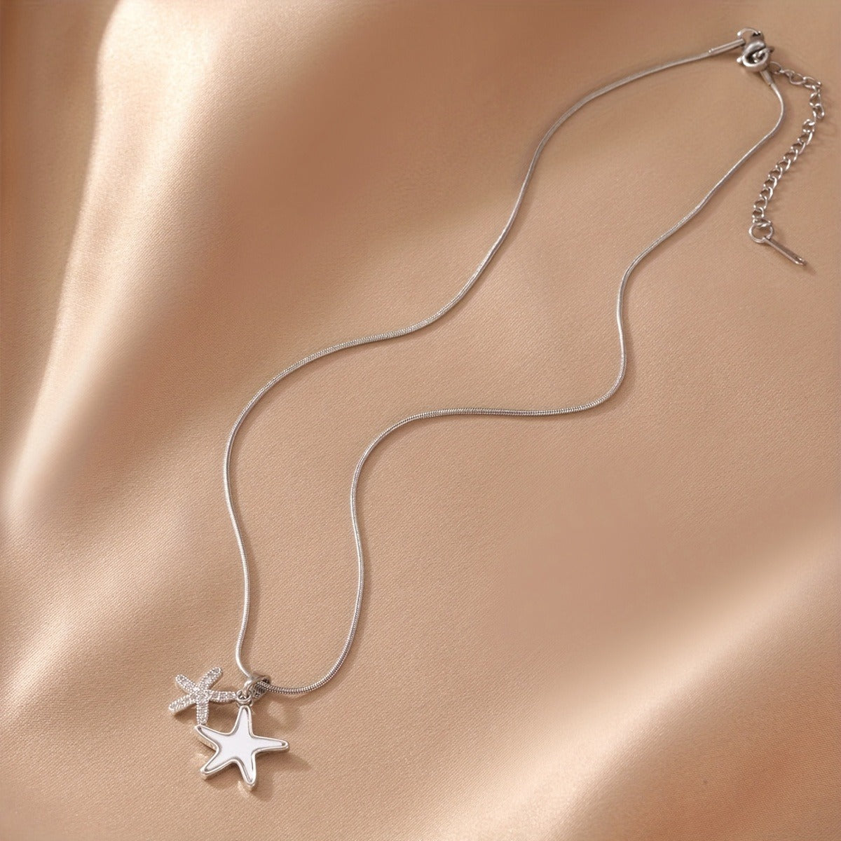 Starfish pendant necklace- silver necklace on a fabric surface